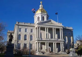 New Hampshire State House with golden dome and front columns.
